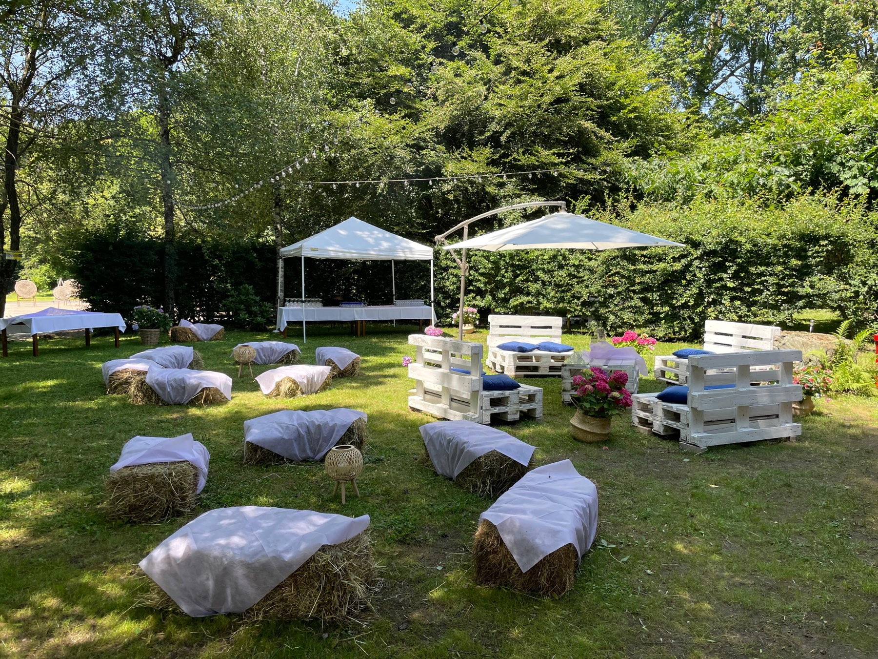 Area lounge per eventi con balle di fieno e sedute in pallet