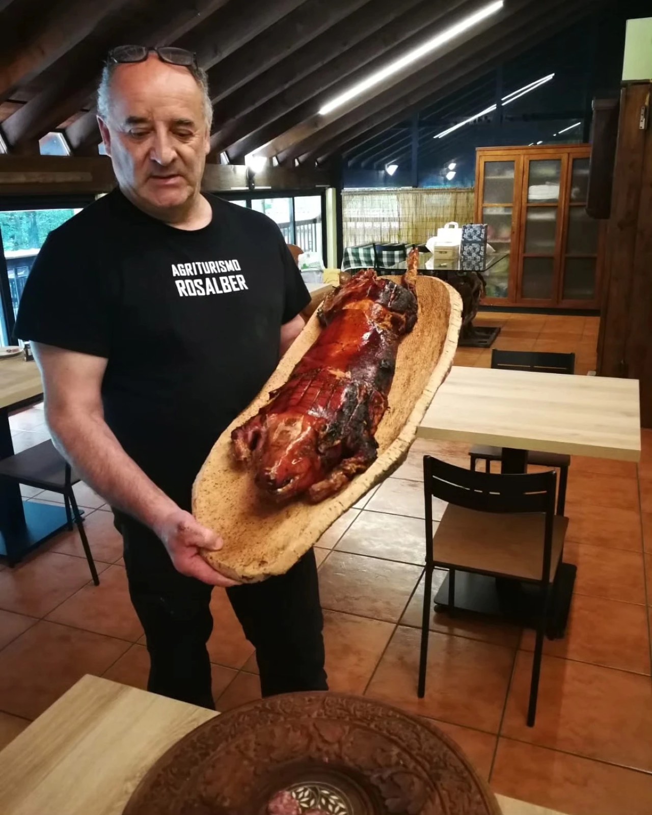 Adelio Pillinini con il porchettone su tagliere di legno intero